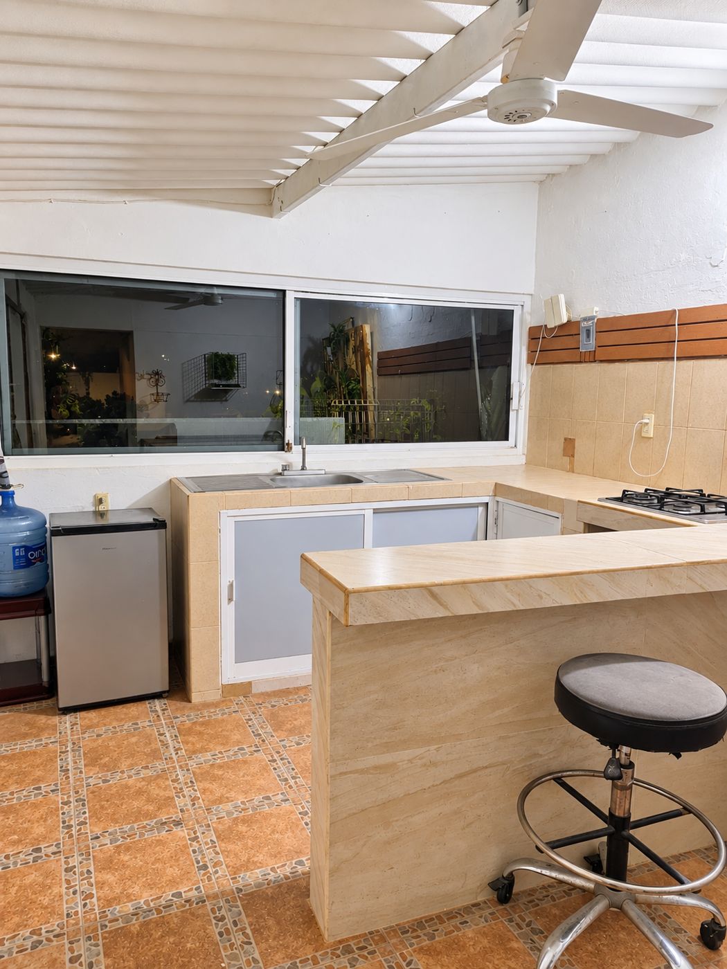Cocina equipada con barra, frigobar y ventilador