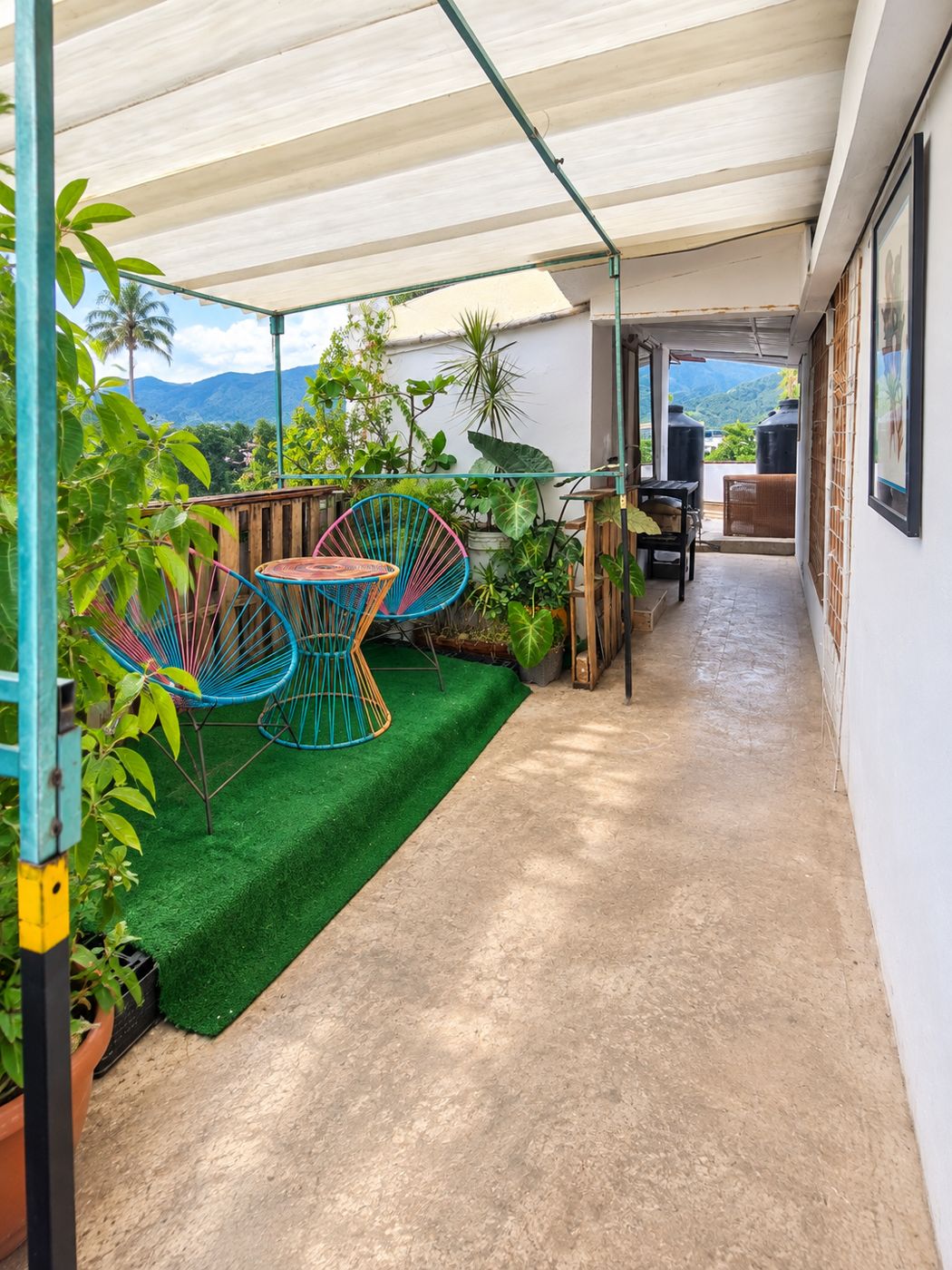 Terraza con sillas de colores y vista verde