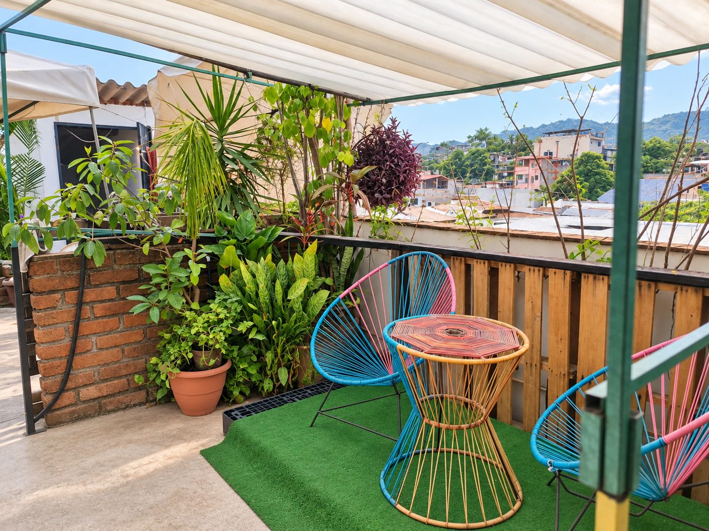 Terraza con sillas artesanales de colores y vista a la montaña